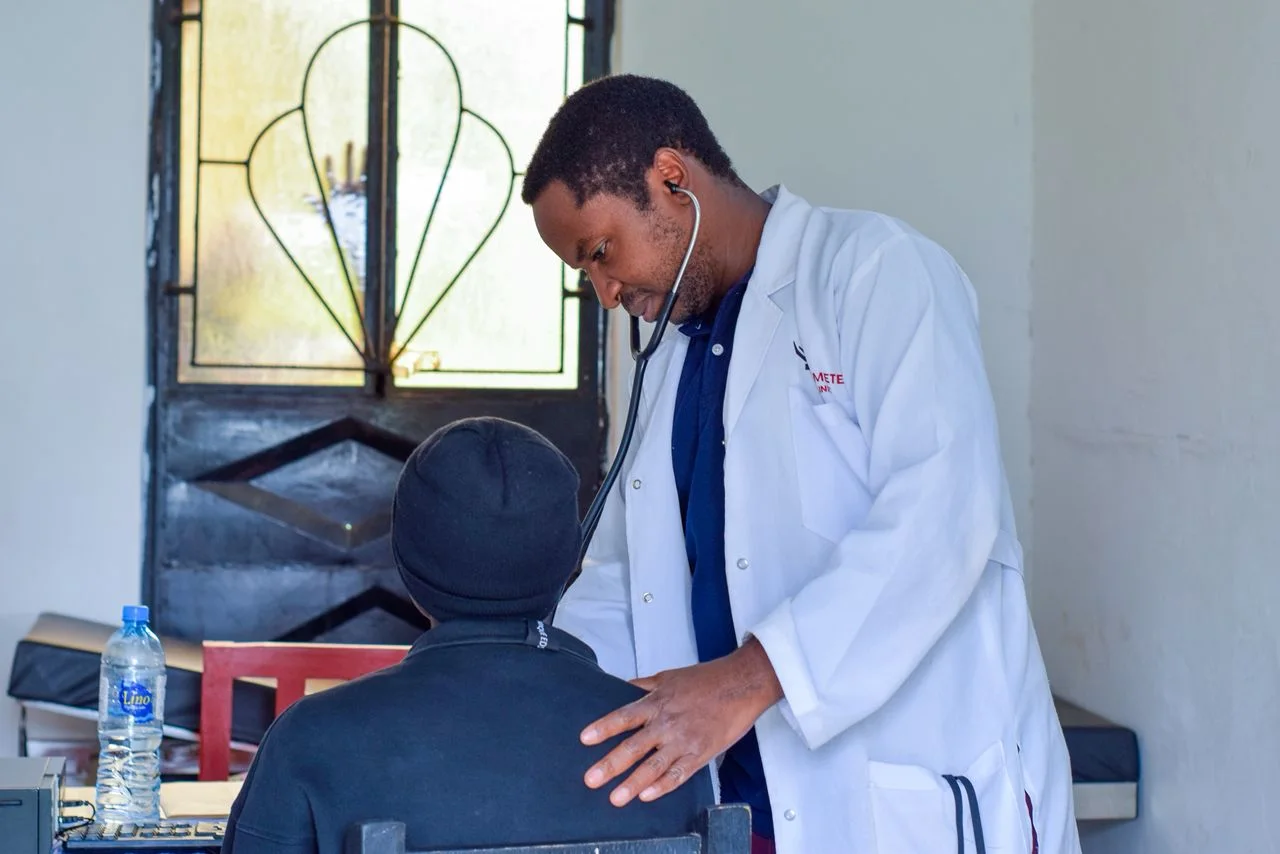 A clinician listening to a patient's chest with a stethoscope