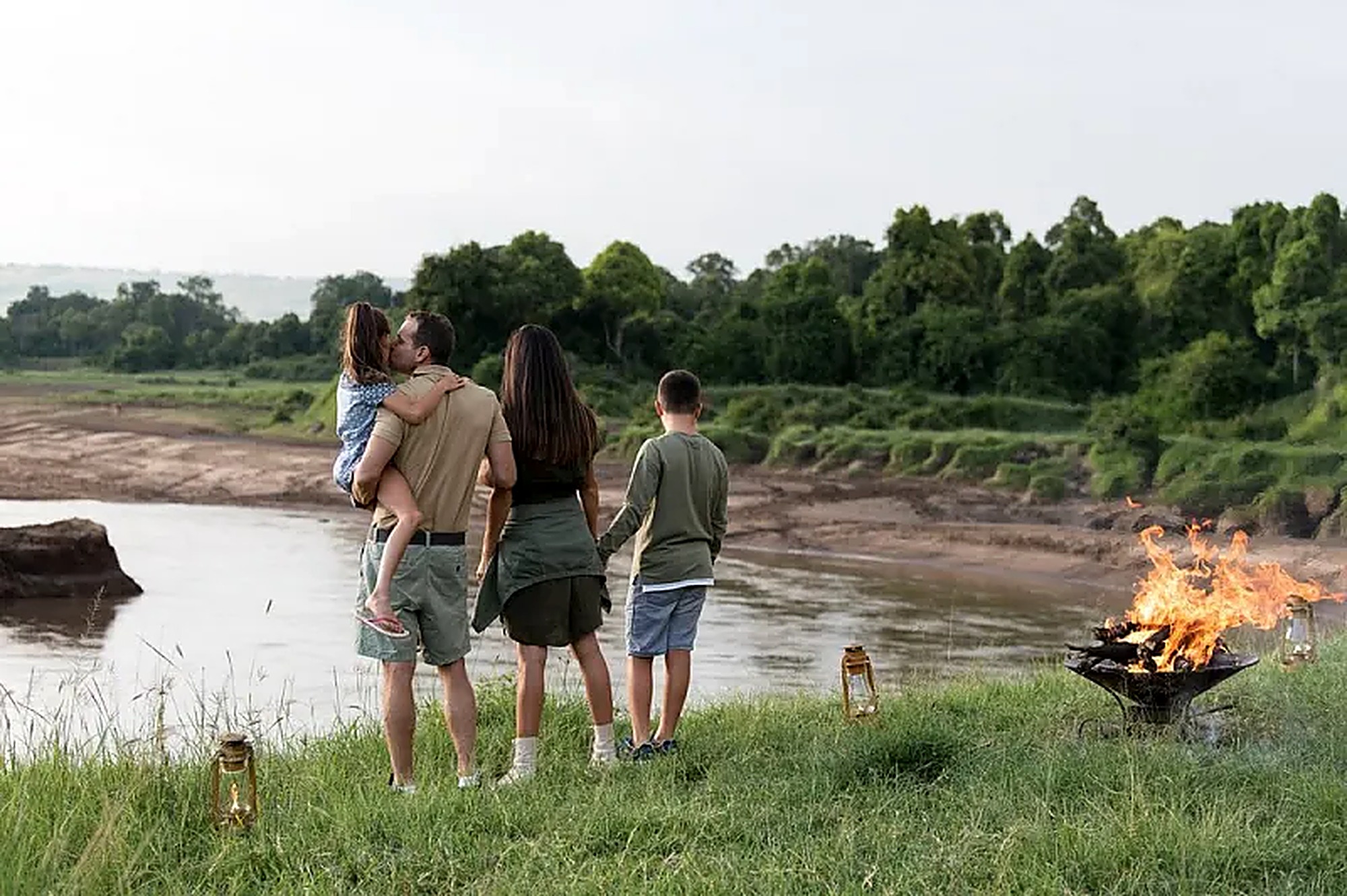 A mother and two children on a walking safari, an elephant grazing in the distance
